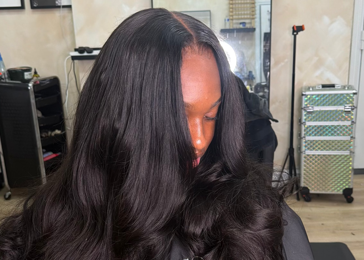 A client in the studio with a long curly install